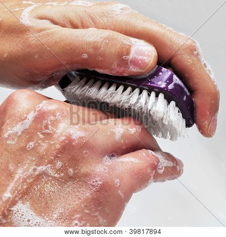 un uomo lavando le mani con sapone e spazzola una chiodo