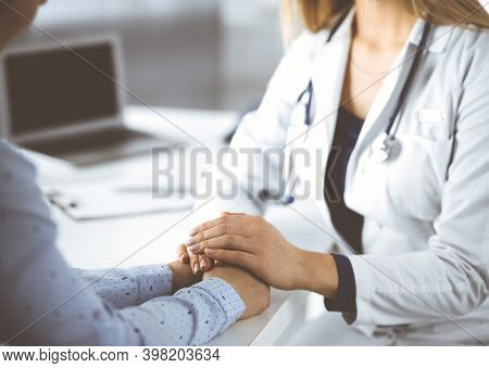 Unknown Woman-doctor Is Holding Her Patients Hands, Discussing Current Health Examination, While The