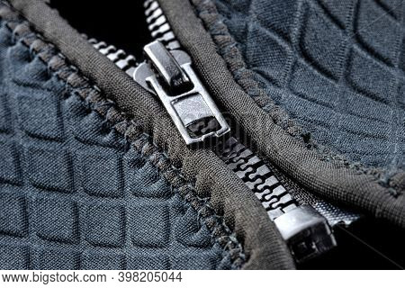 Macro Shot Of A Half-closed, Plastic Zipper In A Modern Blue Garment.