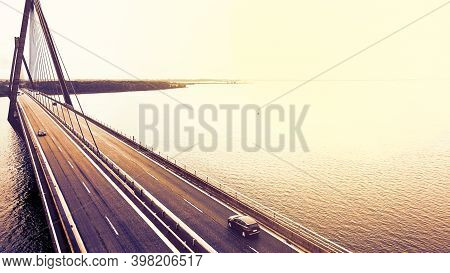 Large Highway Bridge With Traffic Passing Over A Bay At Sunset.