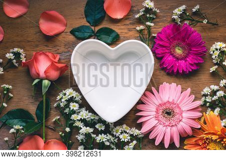 Rose And Gerbera Flower Decoration With Heart Shape Empty Bowl On Rustic Wooden Table, Copy Space