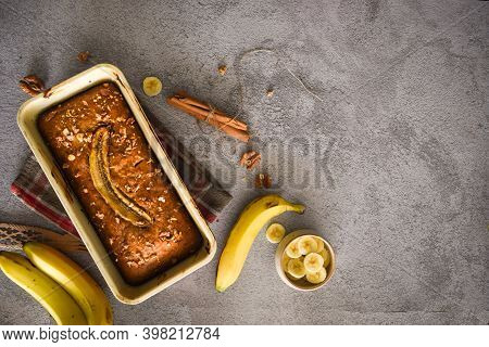 Freshly Baked Multigrain Banana Bread  On Grey Background With Banana, Cinnamon And Nuts. Bake Shop,