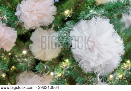 Christmas Tree Decorated With Garland And White Fatin Bows.
