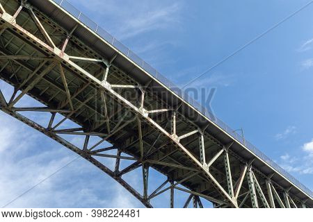 View From Underneath An Old Arch Highway Bridge Silhouetted Against A Blue Sky, Creative Copy Space,