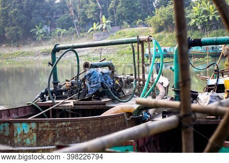 Old Dredger Bounded Beside The Bamboo Bridge On A Small River In Bangladesh