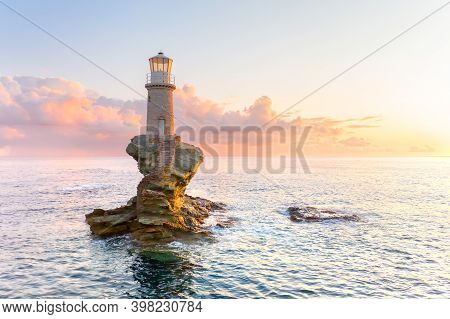 The Beautiful Lighthouse Tourlitis Of Chora At Night. Andros Island, Cyclades, Greece