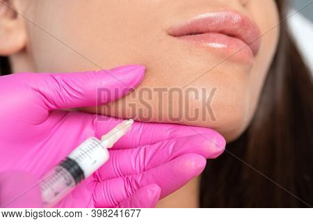 Cosmetologist Makes Lipolytic Injections To Burn Fat On The Chin, Cheeks And Neck Of A Woman Against