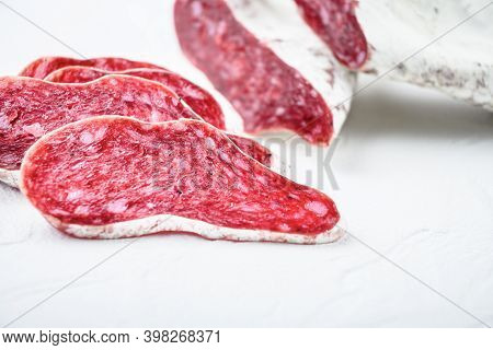 Sliced Cuts Of Longaniza, Dry Cured Spanish Sausage On White Surface