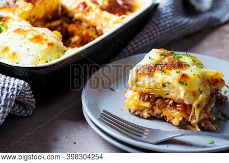 Traditional Greek Potato And Meat Casserole With Cheese - Moussaka, Dark Background. Greek Cuisine C