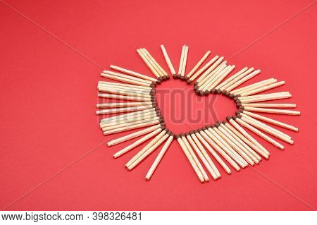 Matchsticks In The Shape Of A Heart On Red Background