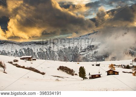 Small cottage in magic sunset in Dolomite mountains, Alpe di Siusi, Italy in winter