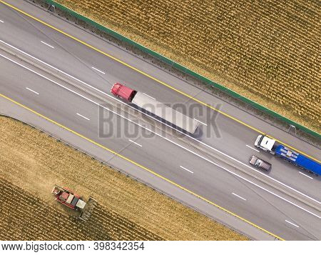 Two Trucks On The Higthway. Cargo Delivery Driving On Asphalt Road Along The Agriculture Fields. See