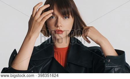 Attractive Casual Girl With Red Lips Preening Her Hair Looking Confident On Camera Over White Backgr