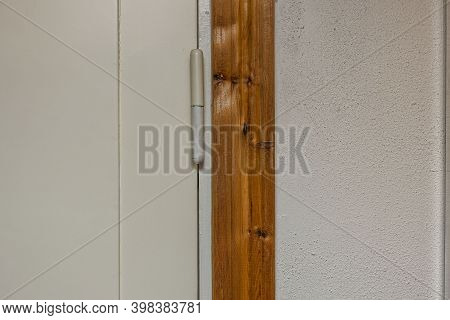 Close Up View Of Closed White Door  With Retro Door Hinge.