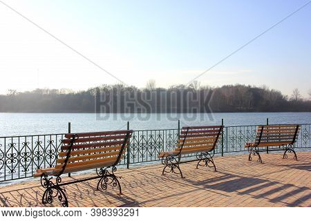 Bench On The Lake In The Park Zone. Social Distansing During Pandemic. Empty Park During Covid-19 Qu