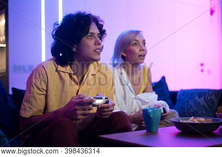 Handsome Young Man Teaching How To Play The Video Games To His Girlfriend, On The Couch, Concept Abo