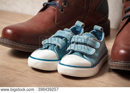 Mens And Childrens Shoes On A Wooden Floo
