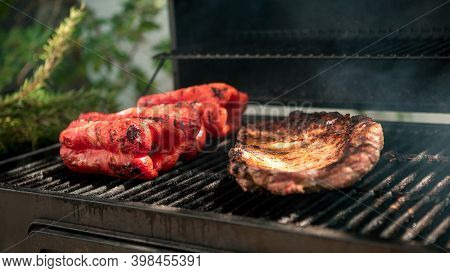 Cooking Pork Ribs With Red Peppers On Bbq Grill. Cook A Delicious Grilled Meat.