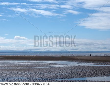 The Beach At Blundell Sands Near Sefton, Southport With Water From The Incoming Tide Reflecting Clou