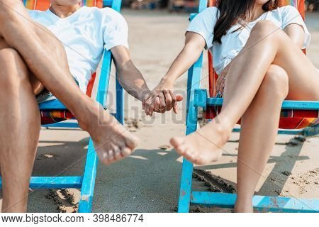 Couple Sitting On The Deck Chairs At The Beach. Honymoon, Love, Travel Or Vacation Concept.