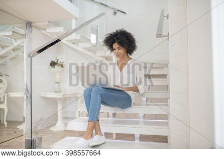 Woman Working On Laptop While Sitting On Steps