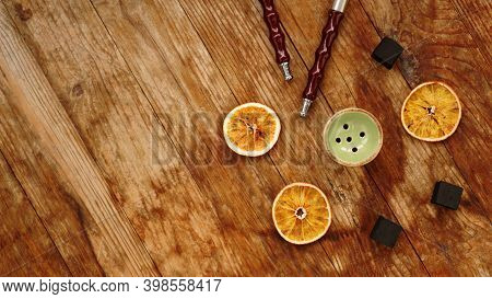Hookah Bowl On Wooden Background With Dry Oranges, Coal And Hookah Pipes