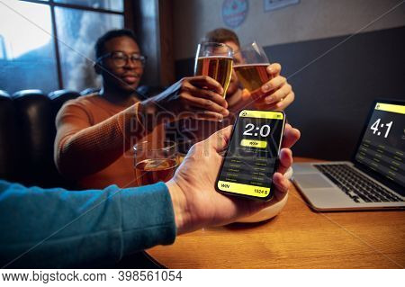 Winners. Excited Fans In Bar With Beer And Mobile App For Betting, Score On Their Devices. Screen Wi