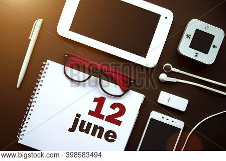 June 12nd. Day 12 Of Month, Calendar Date. Office Workplace With Laptop, Notebook, Office Supplies A