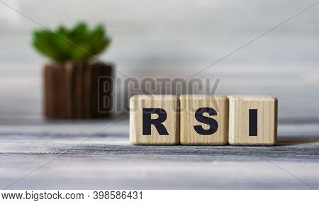 Rsi(relative Strength Index) - Word On Wooden Cubes Against The Background Of A Light Board With Bea