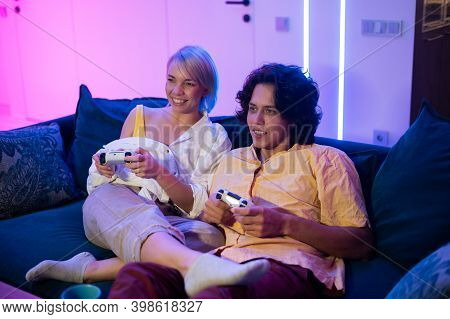 Handsome Young Man Teaching How To Play The Video Games To His Girlfriend, On The Couch, Concept Abo