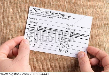 The Coronavirus Vaccination Card Is Held In The Hands. The Concept Of Defeating Covid-19