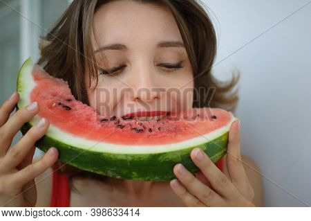 Close Up Indoors Portrait Of Beautiful Woman With Short Hair And Sensual Lips Eating A Piece Of Wate