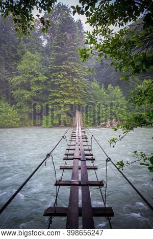 Scene With Mountain River And Suspension Bridge