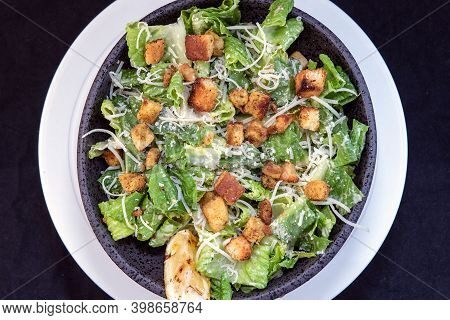 Overhead View Of Delicious Caesar Salad Topped With Parmesean Cheese And Dressing Makes The Mouth Wa