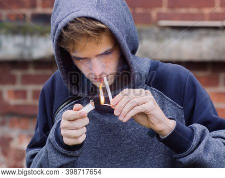 Problem Teenager Smoking Cigarette On Brick Wall Background.