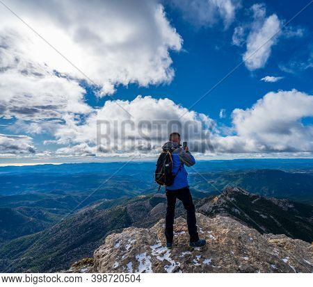 Unrecognizable Man Taking Photos On Top Of The Mountain