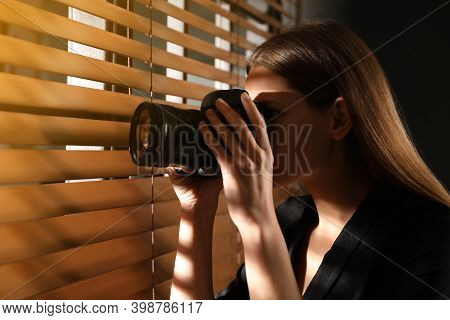 Private Detective With Camera Spying Near Window Indoors