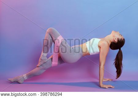 Young Healthy Woman Practicing One Legged Reverse Plank Pose, Enjoying Fitness Lifestyle, Exercising