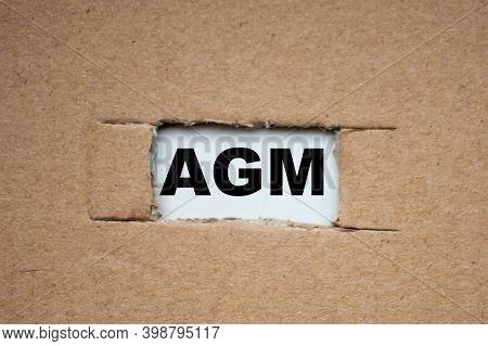 A Cut-out Hole In The Paper Cardboard, And Under It A Piece Of Paper With The Word Agm. The Word Agm