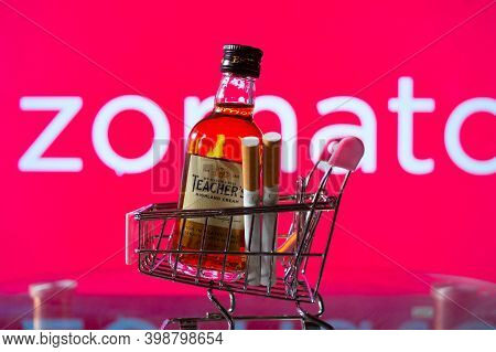 A Bottle Of Whiskey In A Trolley In Front Of A Zomato Board