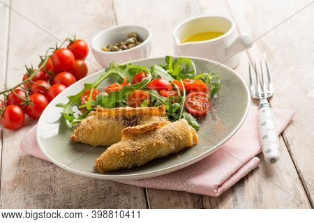 rolled sword fish with capers arugula and tomatoes salad