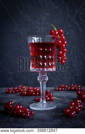 One Beautiful Glass Goblet With A Red Currant Drink (alco/n/a) And A Bunch Of Currants On The Edge O