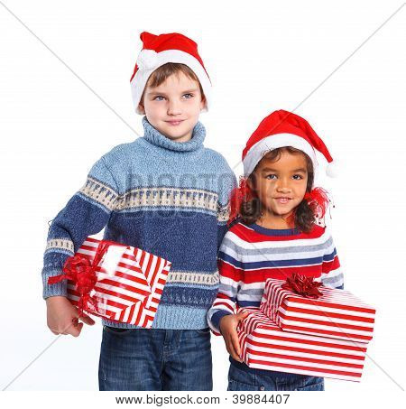 Niños pequeños en el sombrero de Santa Claus con caja de regalo