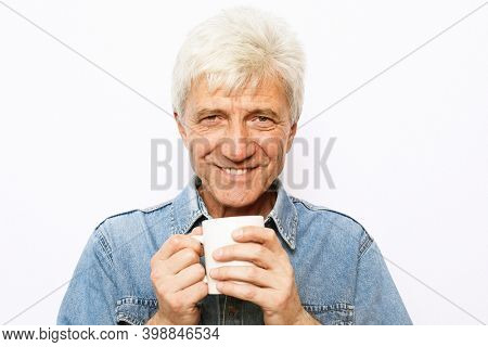 lifestyle, food and people concept: Handsome mature man hoding a cup of coffee or tea