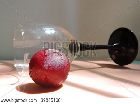 Plum In Water Droplets And A Tall Glass Lies Horizontally