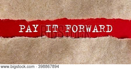 Pay It Forwar Appearing Behind On The Torn Paper.