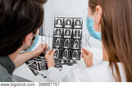 Pulmonologist Wearing In Protective Mask Showing Man Patient A Ct Scan Of His Lungs. Pneumonia, Coro