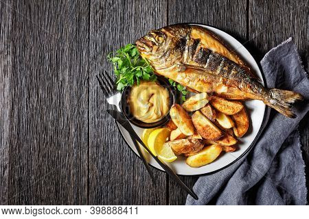 Grilled Sea Bream, Orata, Dorado Fish Served On A Plate With Roasted Potatoes And Mustard, Horizonta