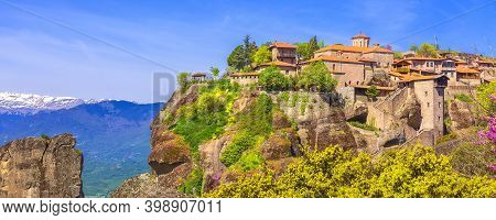 Great Meteoron Monastery On The High Cliff Rock In Meteora, Trikkala, Greece And Snow Mountain Peaks