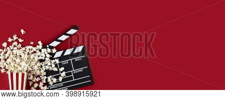 Watching Movie With Popcorn And Clapperboard On Red Background. Movie Goers Accessories, Cinematogra